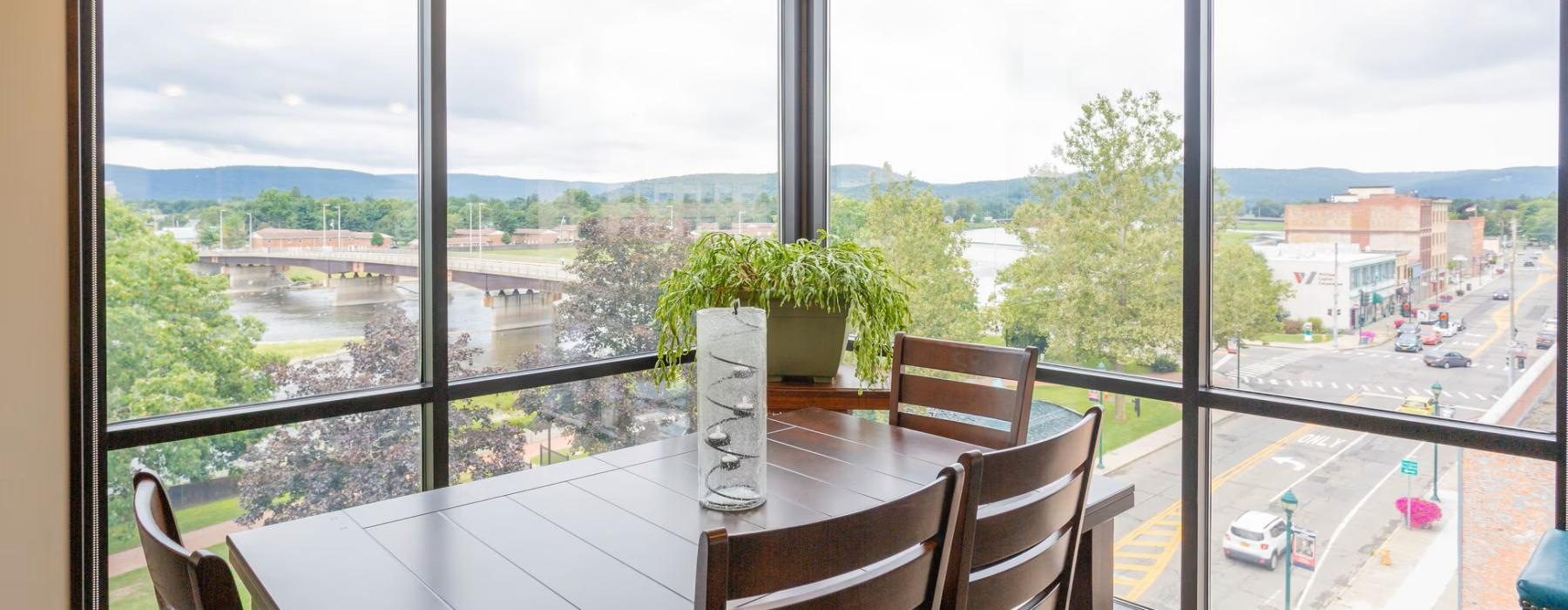 a table with chairs and a window with a view of a city
